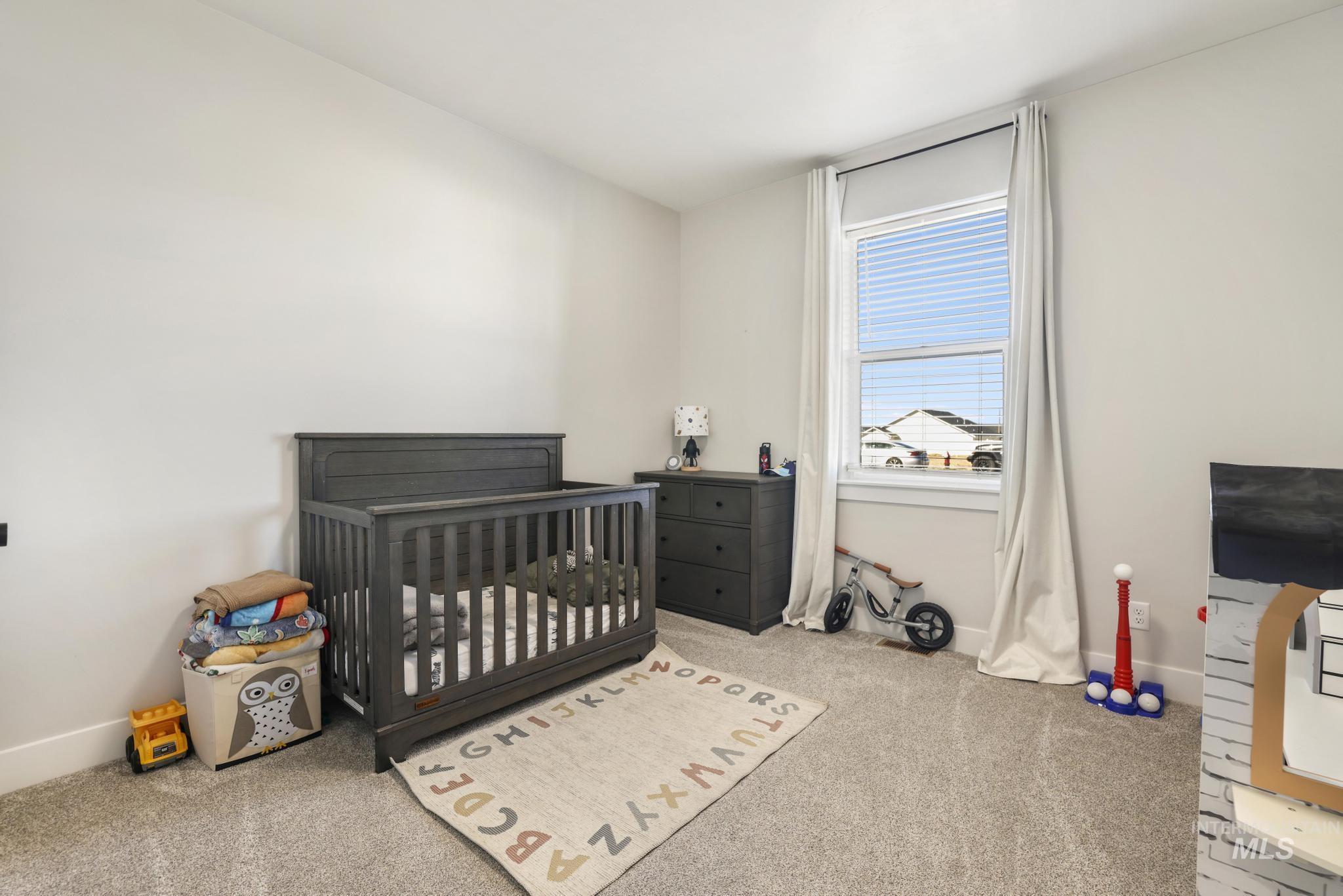 1231 Frank Henry Road Twin Falls, ID 83301 - Photo 22 of 48 Bedroom featuring a crib and carpet floors