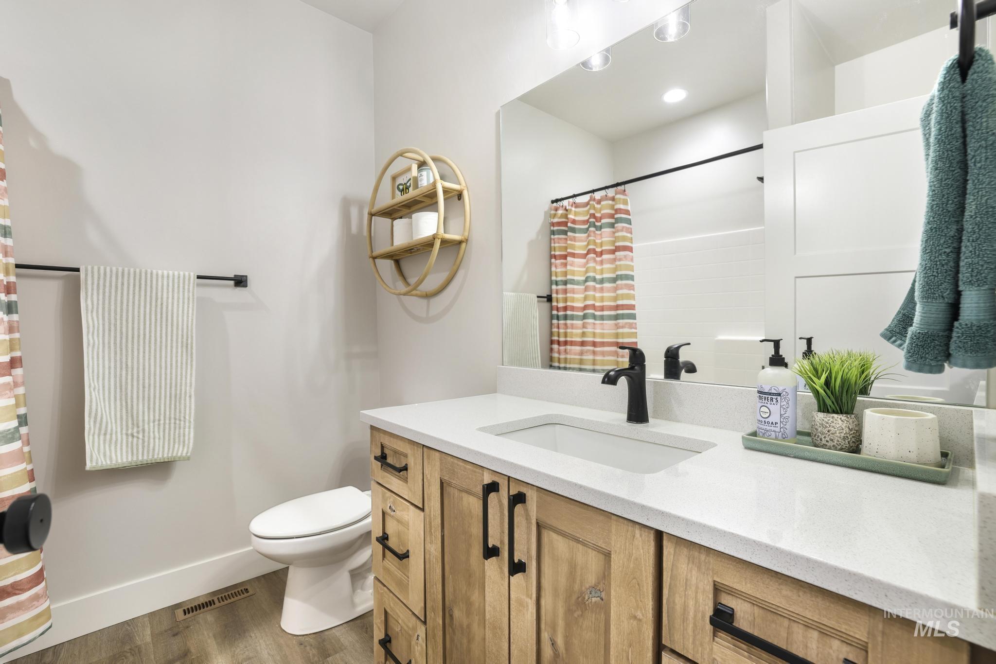 1231 Frank Henry Road Twin Falls, ID 83301 - Photo 24 of 48 Bathroom featuring vanity, a shower with curtain, and wood finished floors