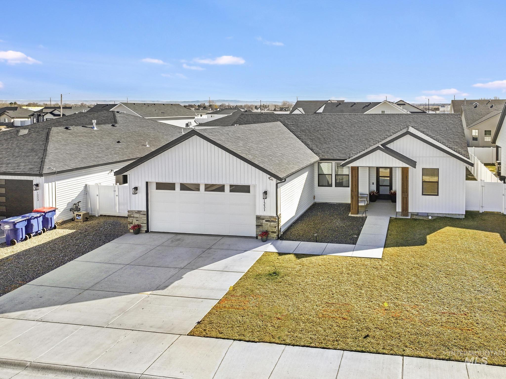 1231 Frank Henry Road Twin Falls, ID 83301 - Photo 34 of 48 Modern farmhouse featuring a shingled roof, a garage, driveway, board and batten siding, and a residential view