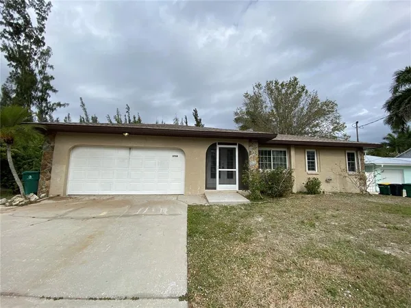 a view of a house with backyard and trees