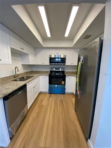 a kitchen with granite countertop stainless steel appliances and wooden cabinets