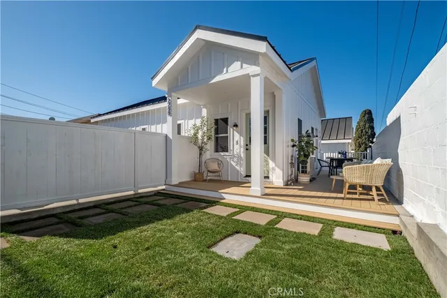 a living room with furniture a chandelier fan and wooden floor