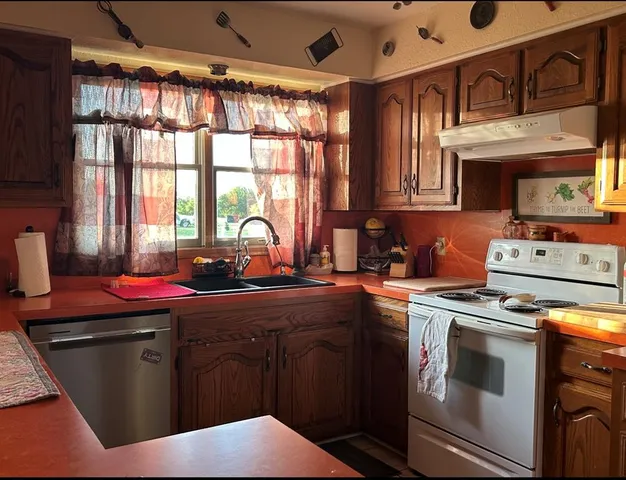a kitchen with stainless steel appliances kitchen island granite countertop a sink stove and cabinets