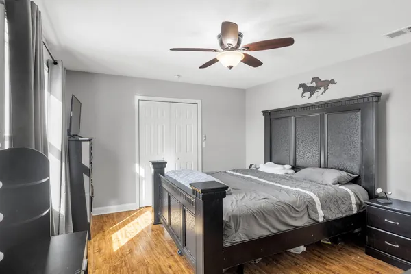 a bedroom with a bed and wooden floor