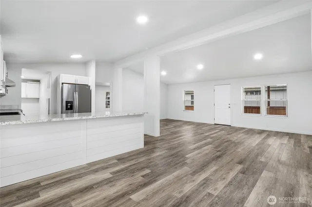 a view of kitchen with stainless steel appliances granite countertop a stove a sink and a refrigerator