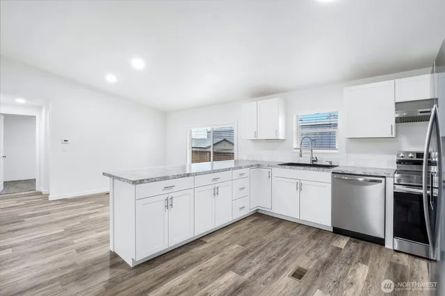 a kitchen with stainless steel appliances a sink dishwasher stove and cabinets
