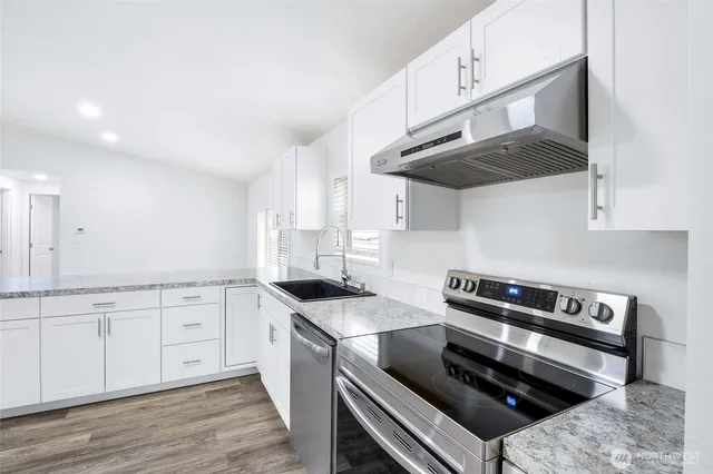 a view of a kitchen with wooden floor and a refrigerator