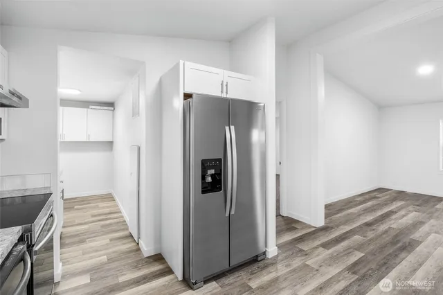 a view of a kitchen with granite countertop a refrigerator and a sink