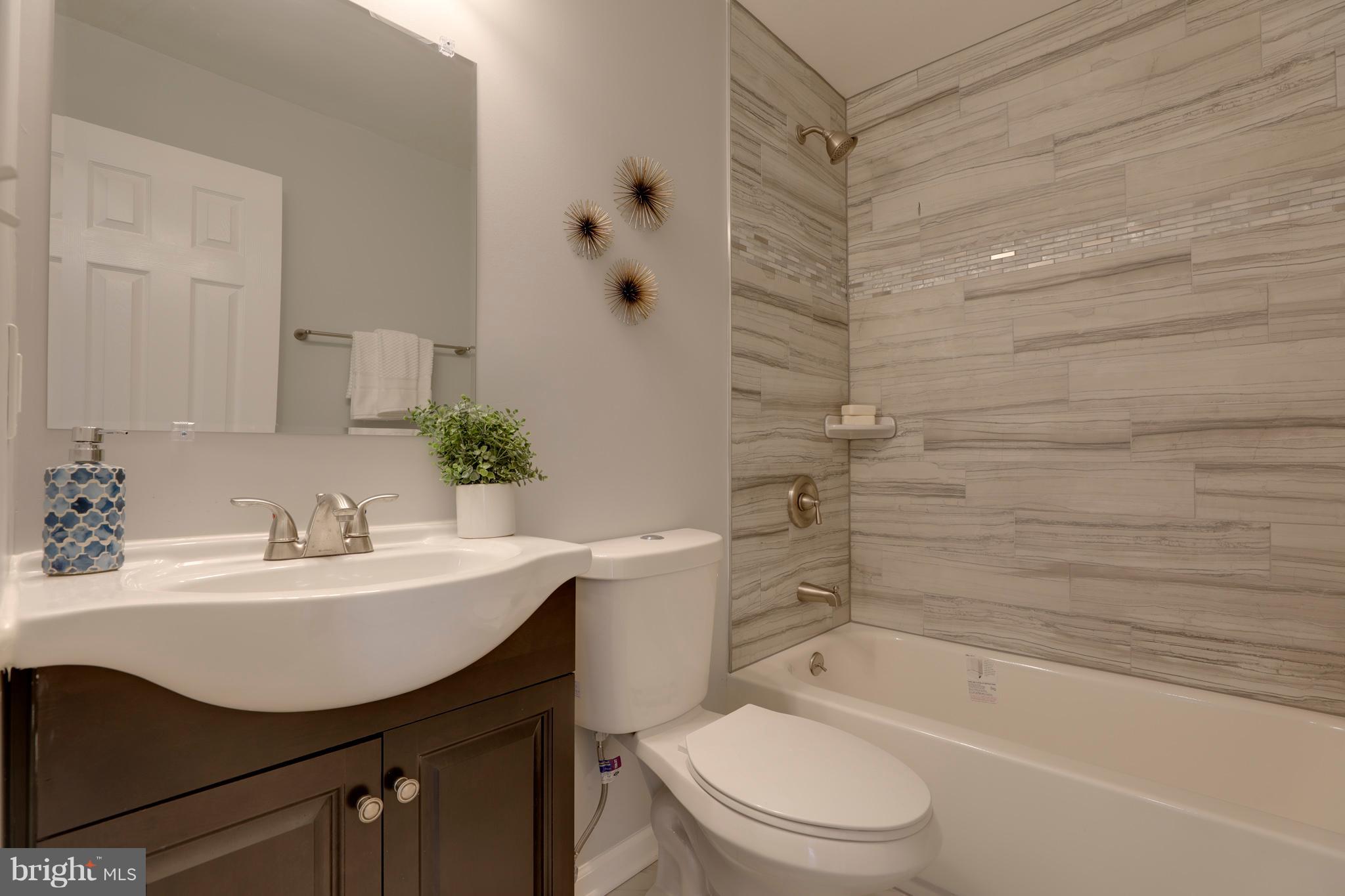 6203 Woodley Road Clinton, MD 20735 - Photo 15 of 38 a bathroom with a sink toilet a mirror and shower
