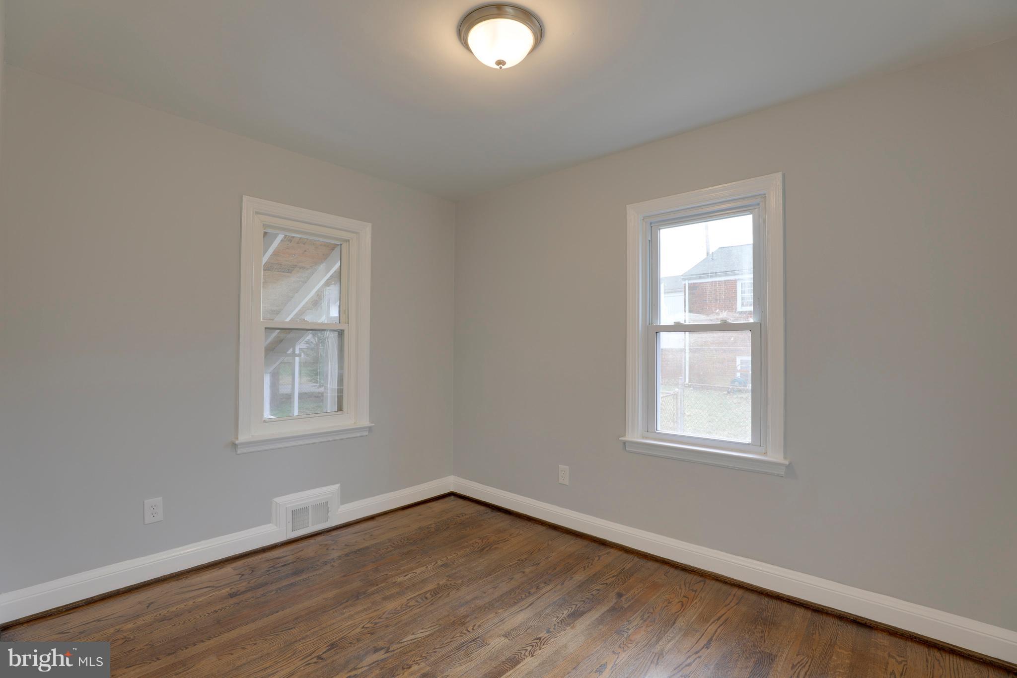 6203 Woodley Road Clinton, MD 20735 - Photo 20 of 38 an empty room with wooden floor and windows