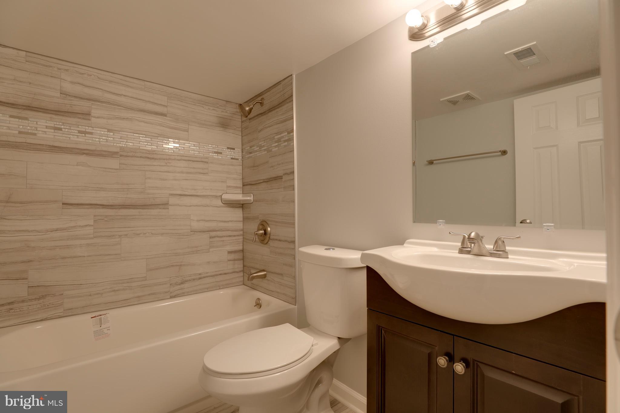 6203 Woodley Road Clinton, MD 20735 - Photo 26 of 38 a bathroom with a sink toilet vanity and shower
