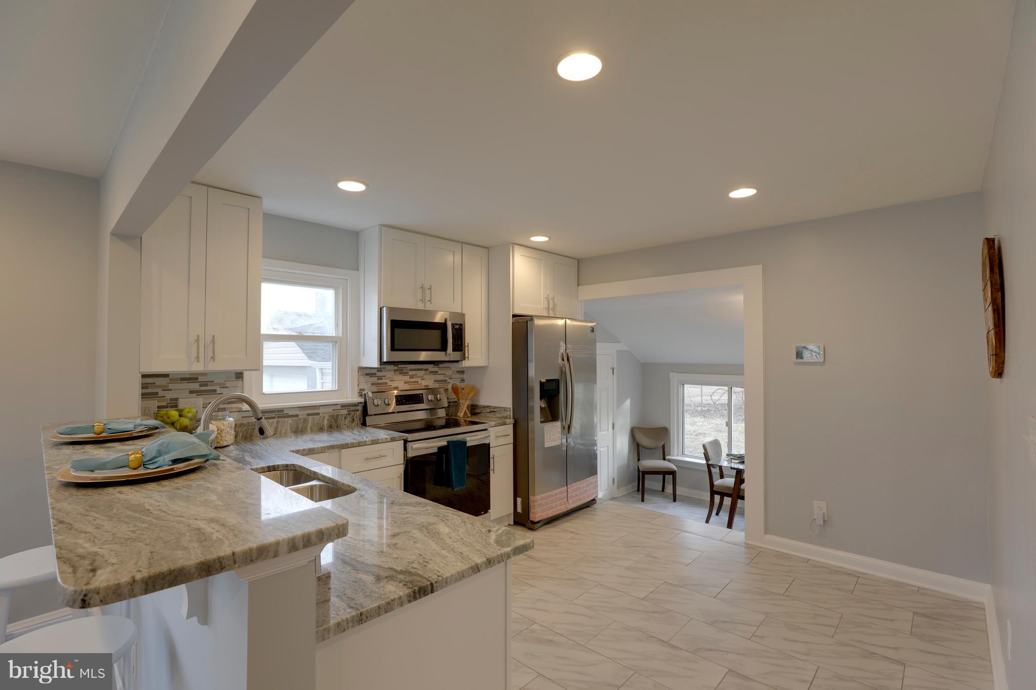 6203 Woodley Road Clinton, MD 20735 - Photo 5 of 38 a kitchen with stainless steel appliances granite countertop a sink stove and refrigerator