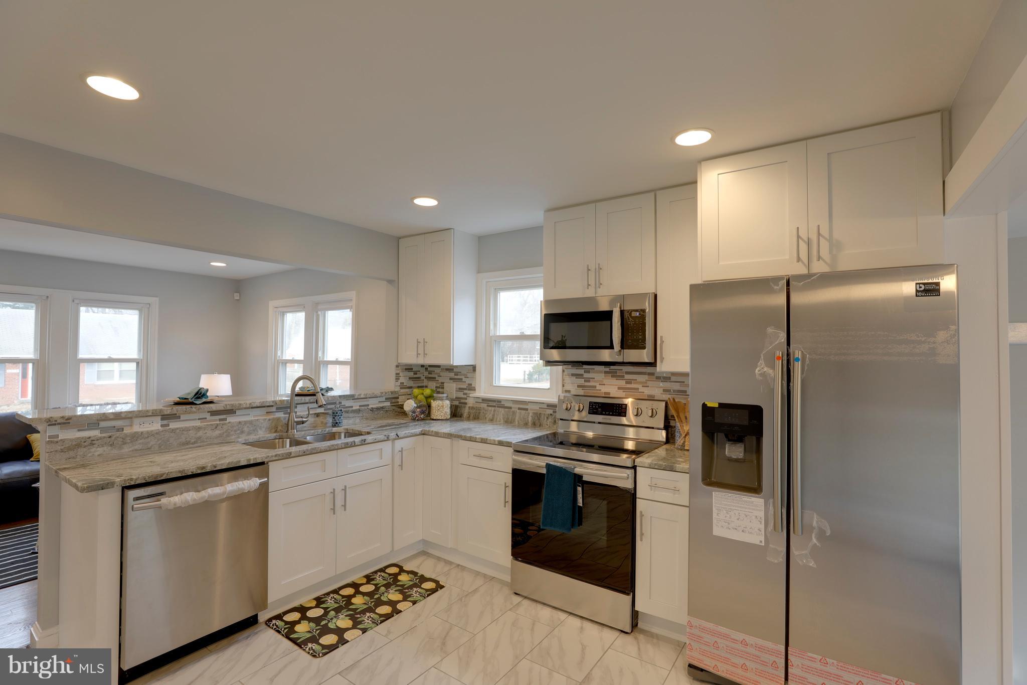 6203 Woodley Road Clinton, MD 20735 - Photo 6 of 38 a kitchen with stainless steel appliances granite countertop a sink a stove a refrigerator cabinets and a window