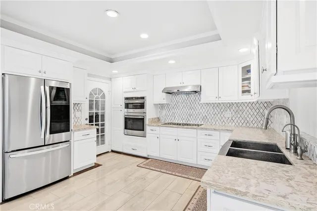 a kitchen with stainless steel appliances granite countertop a refrigerator sink and stove