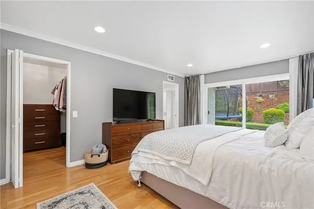 a bedroom with a bed and a flat screen television