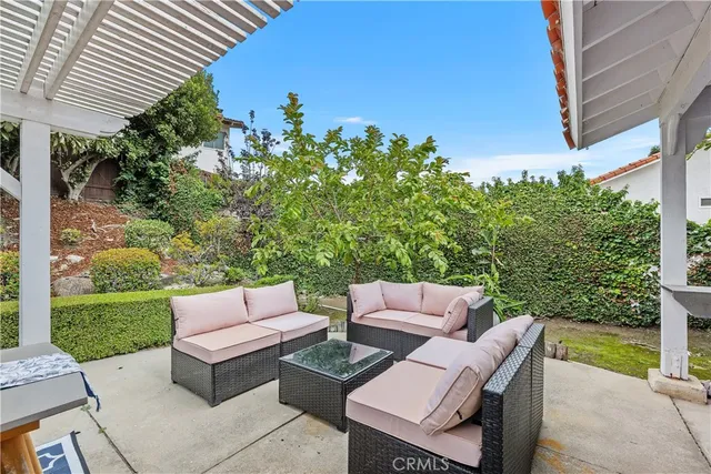 a view of a patio with couches table and chairs and potted plants