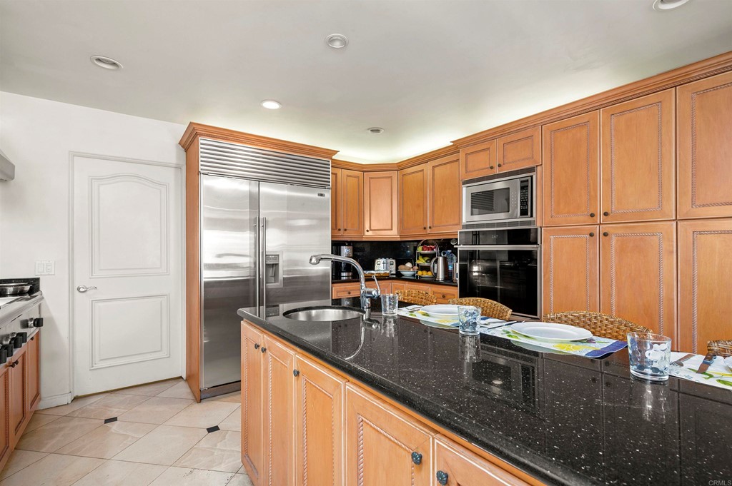 42 Blue Anchor Cay Road Coronado, CA 92118 - Photo 15 of 38 a kitchen with stainless steel appliances granite countertop a sink refrigerator and cabinets