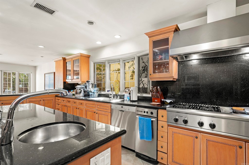42 Blue Anchor Cay Road Coronado, CA 92118 - Photo 16 of 38 a kitchen with stainless steel appliances granite countertop a sink a stove and a microwave