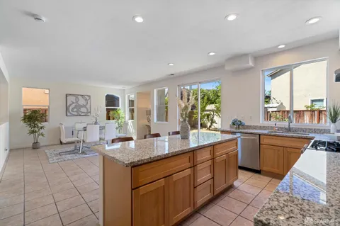 a large kitchen with kitchen island granite countertop a sink and dishwasher wooden cabinets with a granite countertops