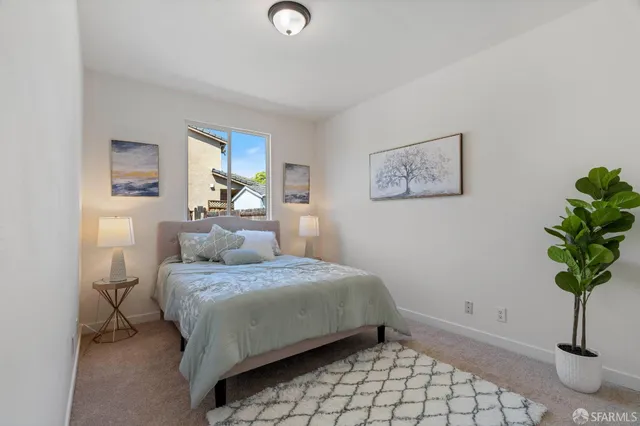 a bedroom with a bed and a potted plant