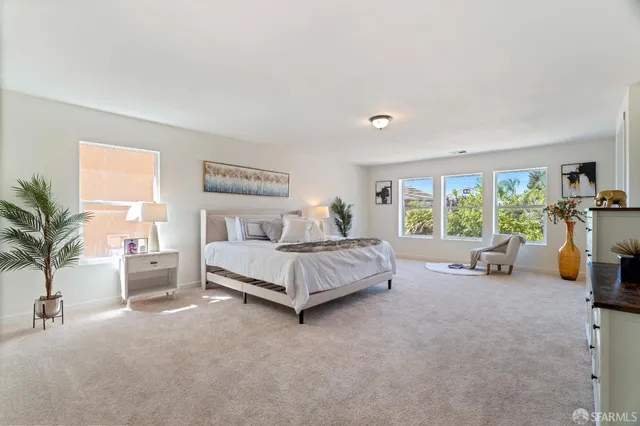 a spacious bedroom with a bed a table and chairs