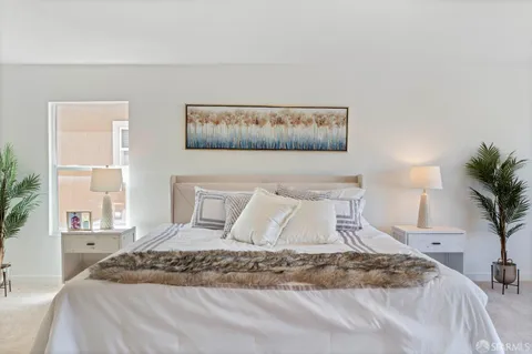 a bedroom with a bed and a potted plant