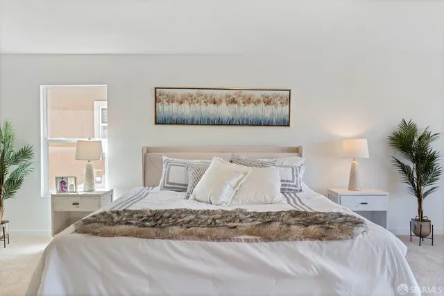 a bedroom with a bed and a potted plant