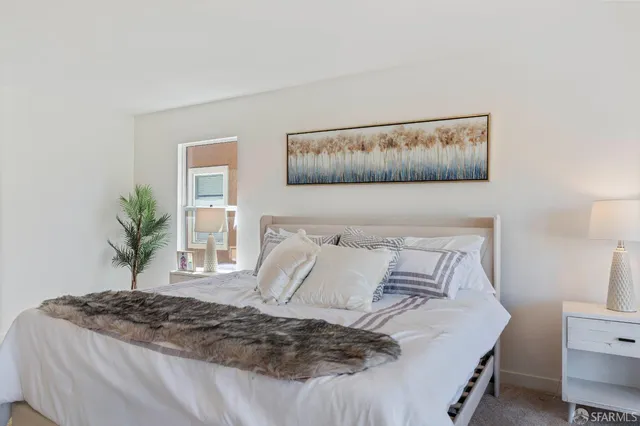 a bedroom with a bed and painting on the wall