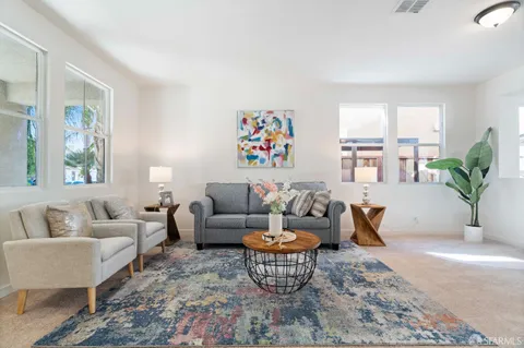 a living room with furniture wooden floor and a large window