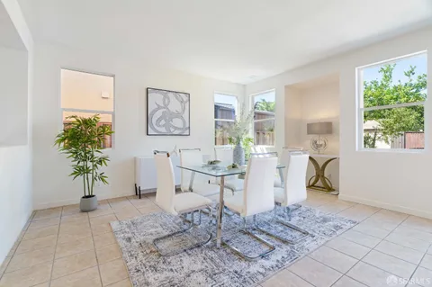 a living room with furniture a window and a potted plant
