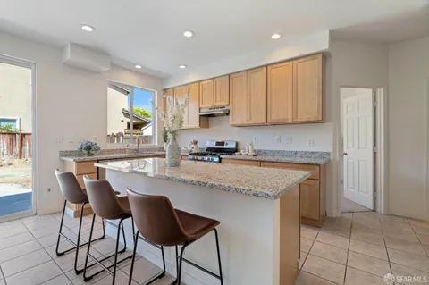 a kitchen with granite countertop a sink a counter top space and cabinets