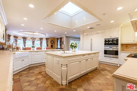 a large kitchen with stainless steel appliances and white cabinets
