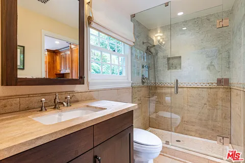 a living room with furniture a flat screen tv and large windows