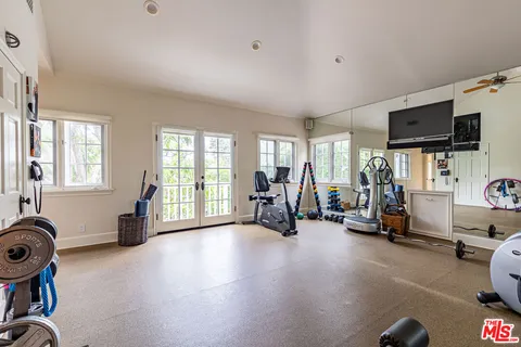 a view of a house with swimming pool lawn chairs under an umbrella