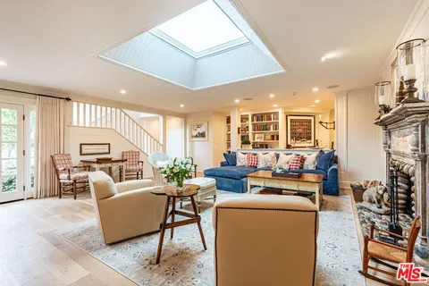 a living room with furniture fireplace and a large window