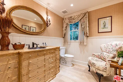 a spacious bathroom with a toilet a sink and a mirror