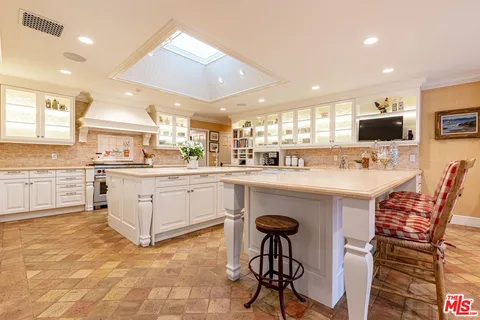 a kitchen with stainless steel appliances kitchen island granite countertop a sink and cabinets