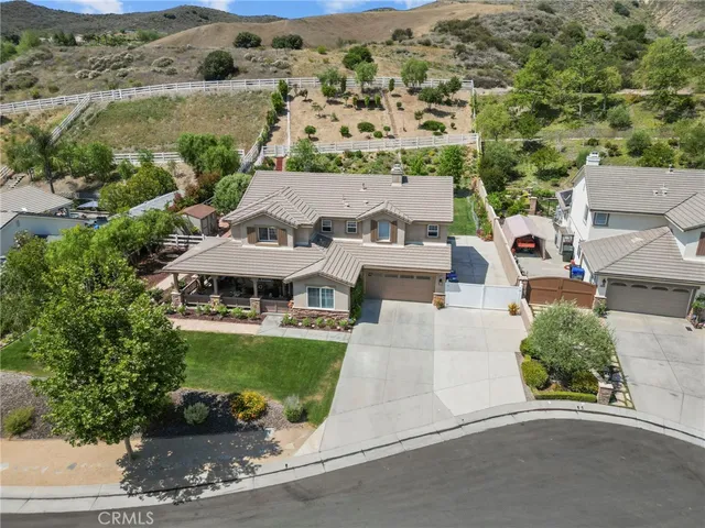 an aerial view of a house with a garden and lake view