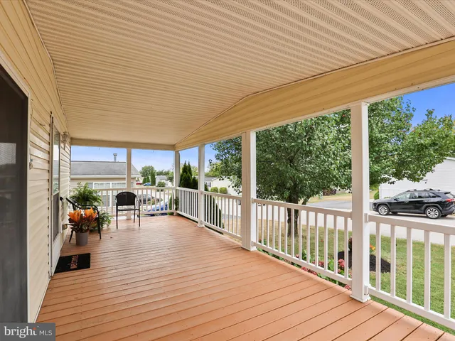 a view of a patio with table and chairs potted plants with wooden floor and fence