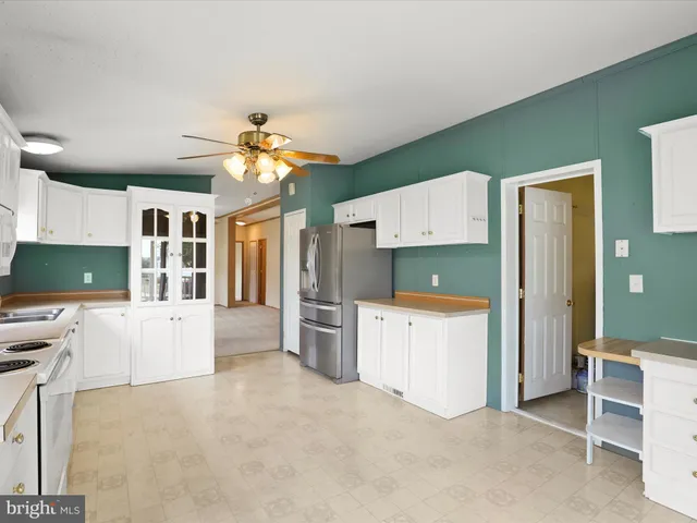 a kitchen with a refrigerator and a stove top oven