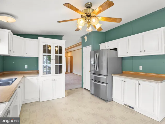 a kitchen with stainless steel appliances white cabinets and a refrigerator