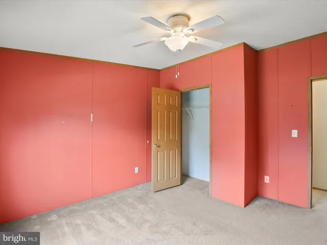 an empty room with a ceiling fan and a window