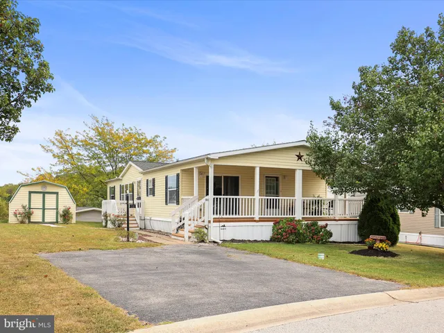 a front view of a house with a garden and trees