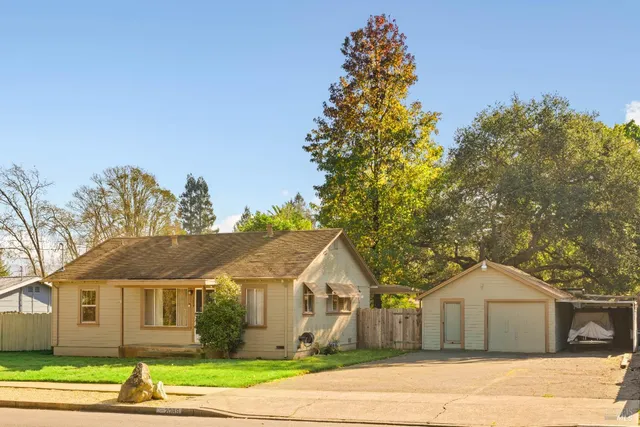 a front view of a house with a garden and trees