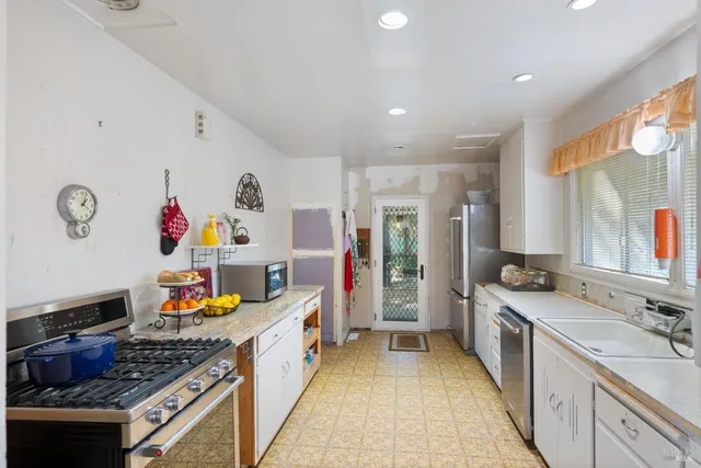 a kitchen that has a lot of cabinets and wooden floor