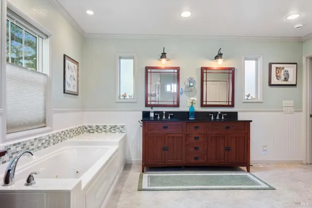 a kitchen with stainless steel appliances granite countertop a stove top oven a refrigerator a sink dishwasher a dining table and chairs with wooden floor