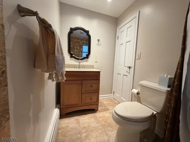 a bathroom with a toilet a sink and mirror