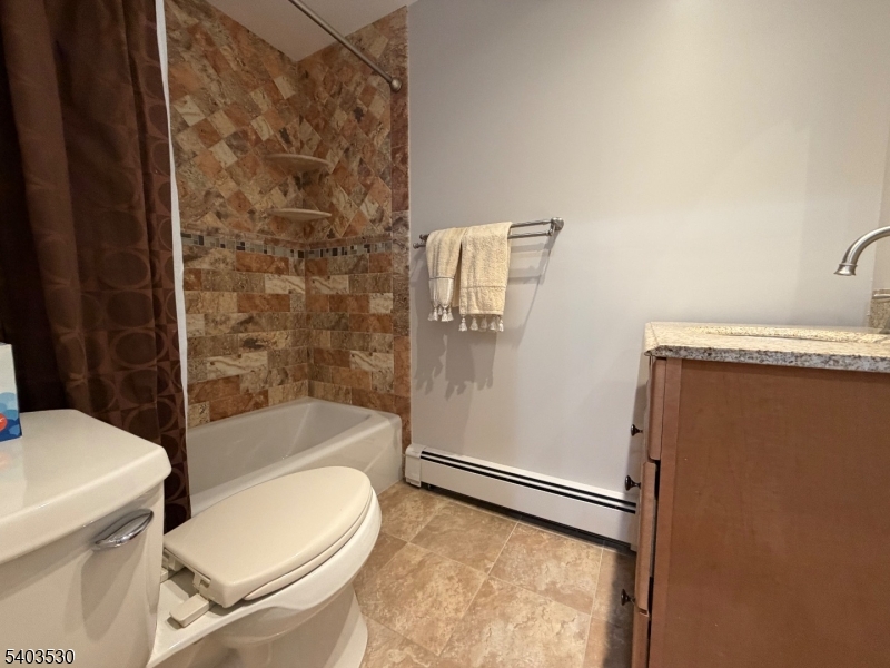 1130 Valley Road, Unit 2A Wayne, NJ 07470 - Photo 9 of 19 a white toilet sitting next to a bath tub and a shower
