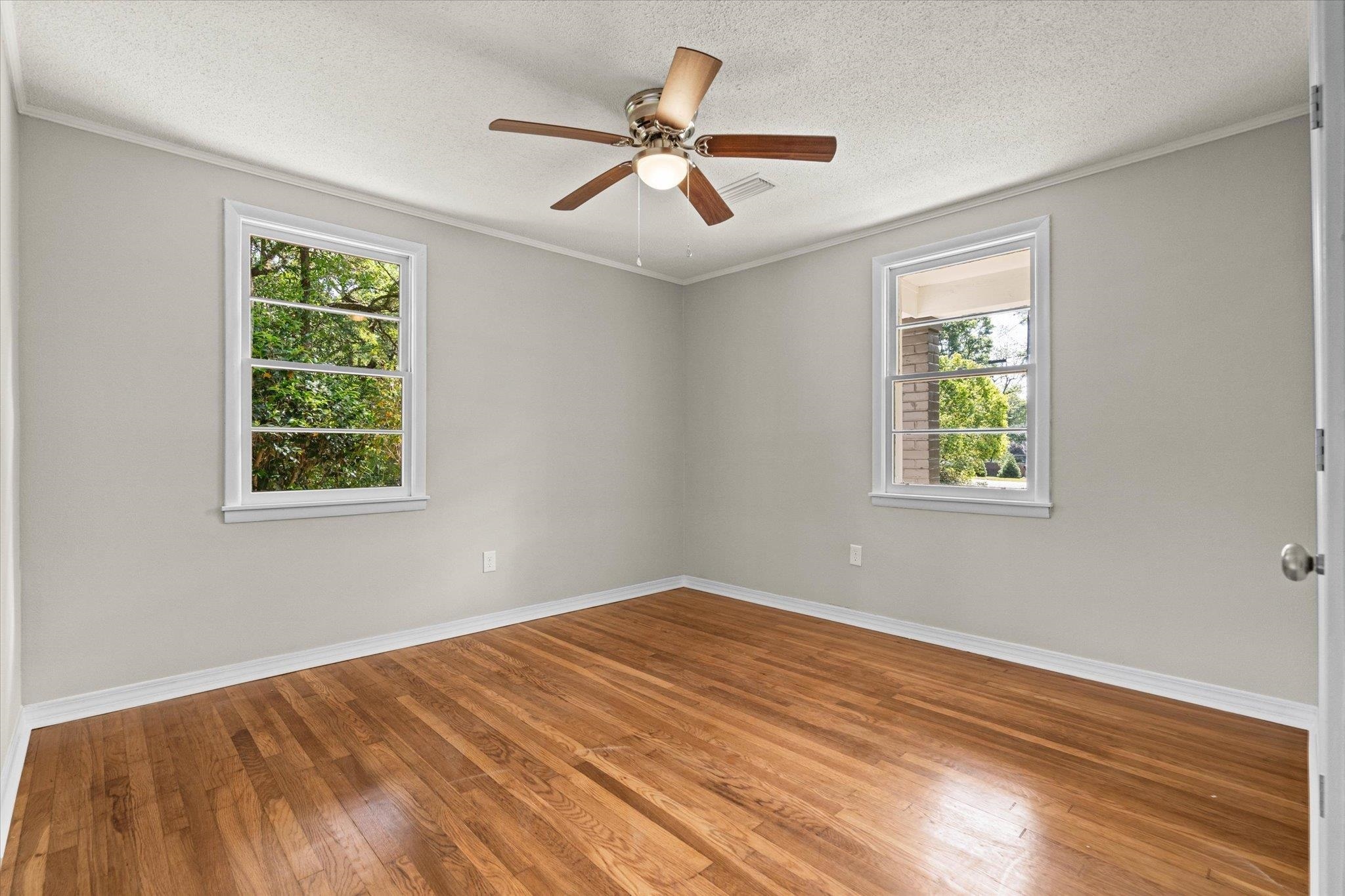 4700 Bit And Spur Road Mobile, AL 36608 - Photo 10 of 21 Empty room featuring ceiling fan, baseboards, wood finished floors, and a textured ceiling
