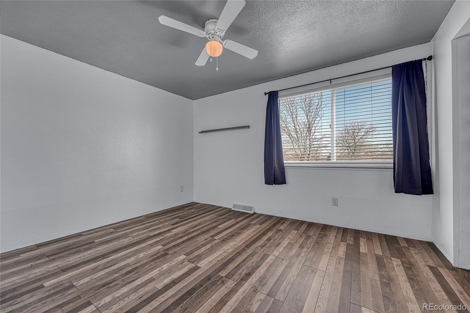 7461 Webster Street Arvada, CO 80003 - Photo 20 of 31 a view of empty room with wooden floor and fan
